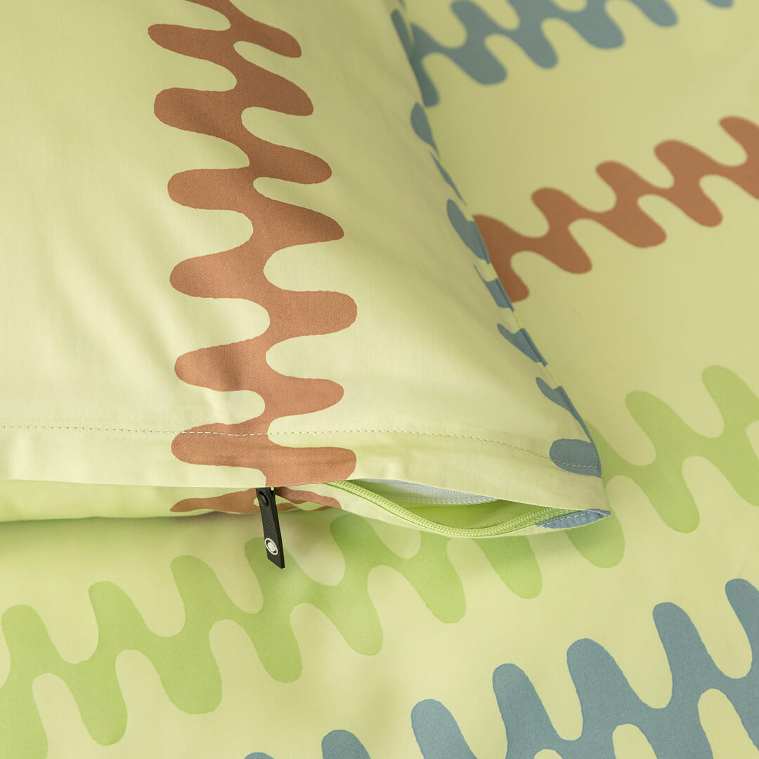 Close-up of a fabric with wavy pattern on a light green background.