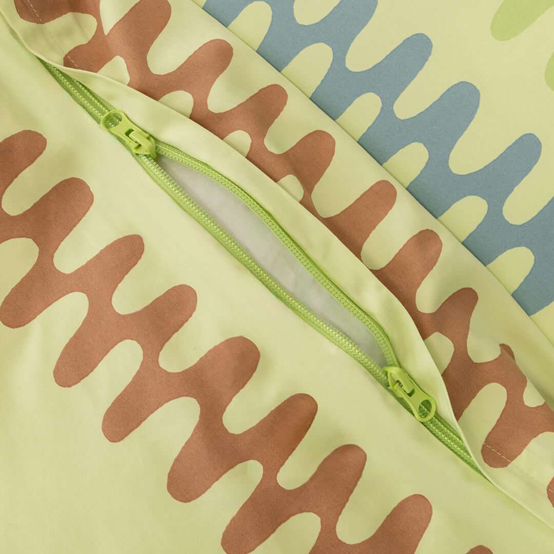 Patterned fabric quilt cover with a green zipper.