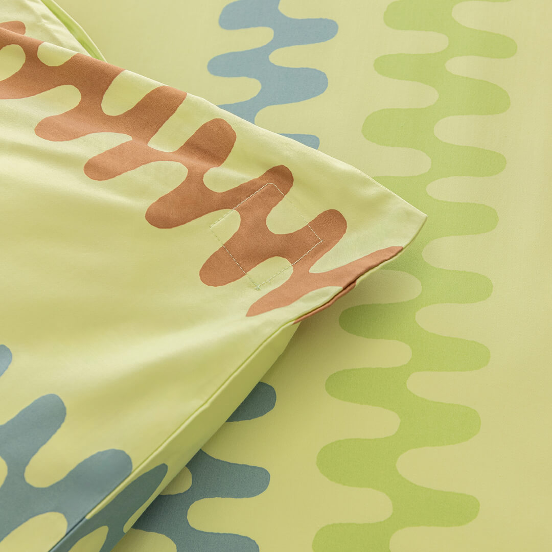 Close-up of colorful fabric with wavy patterns on a light green background. Showcasing magnetic clip corners.