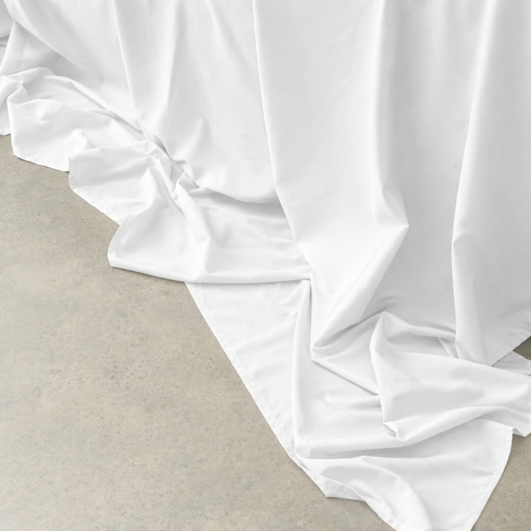 White bamboo-cotton top sheet fabric draped over a surface.