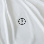 White fabric with a black circular logo and text on a white background.