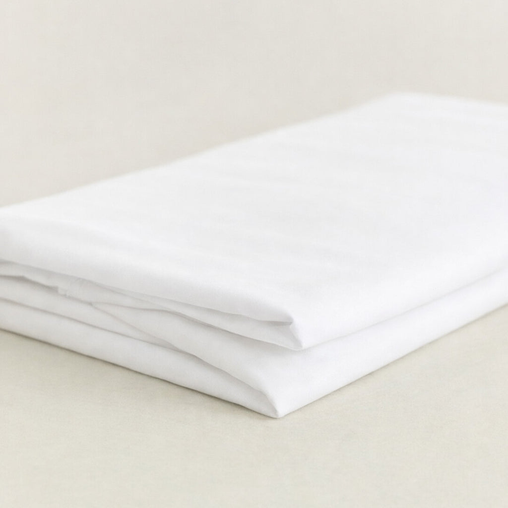 Folded white sheet on a beige surface.