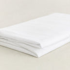 Folded white sheet on a beige surface.