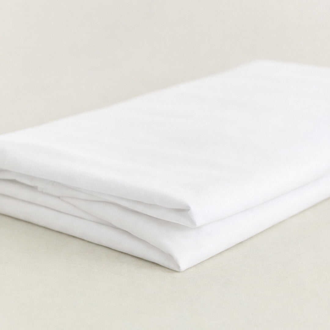 Folded white sheet on a beige surface.