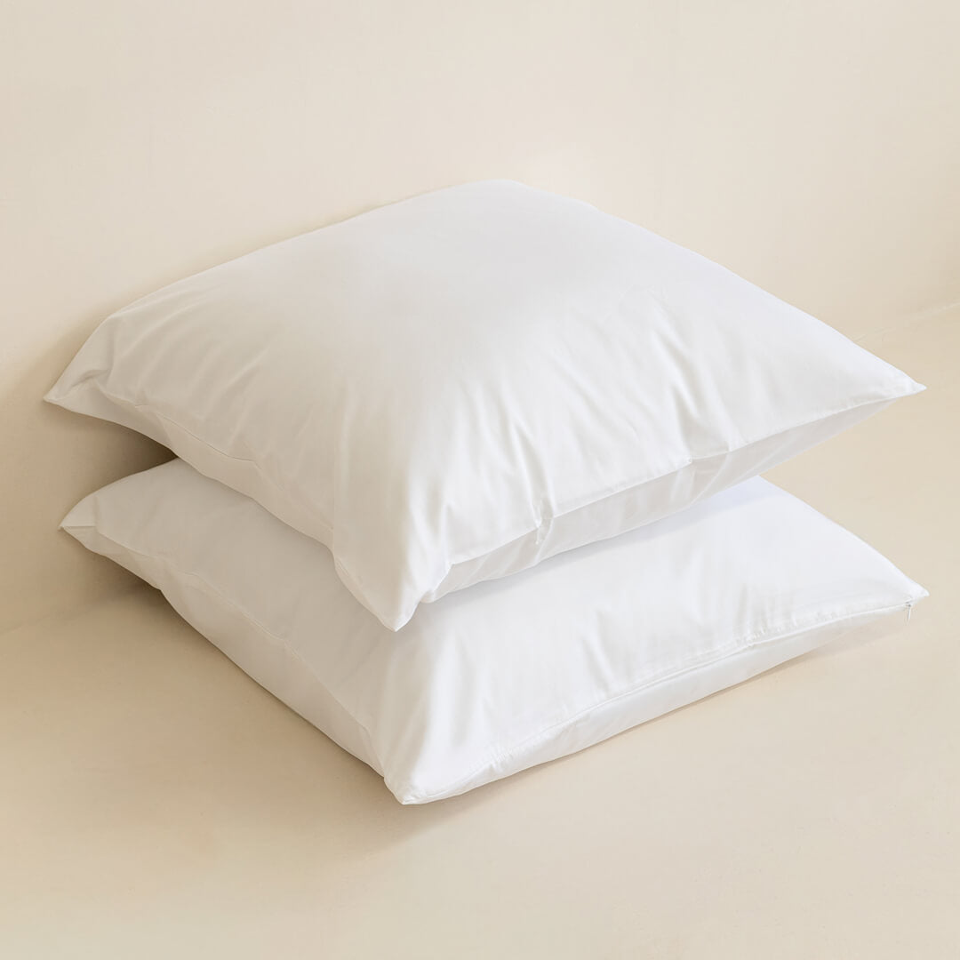 Two white Euorpean pillowcases on top of each other, with a neutral background.