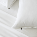 Close-up of bright white pillowcases with concealed zipper closures, showcasing the secure fastening detail and soft fabric construction.