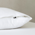 Close-up of a bright white pillowcase featuring a concealed zipper closure, highlighting the secure fastening detail and clean, crisp fabric finish.