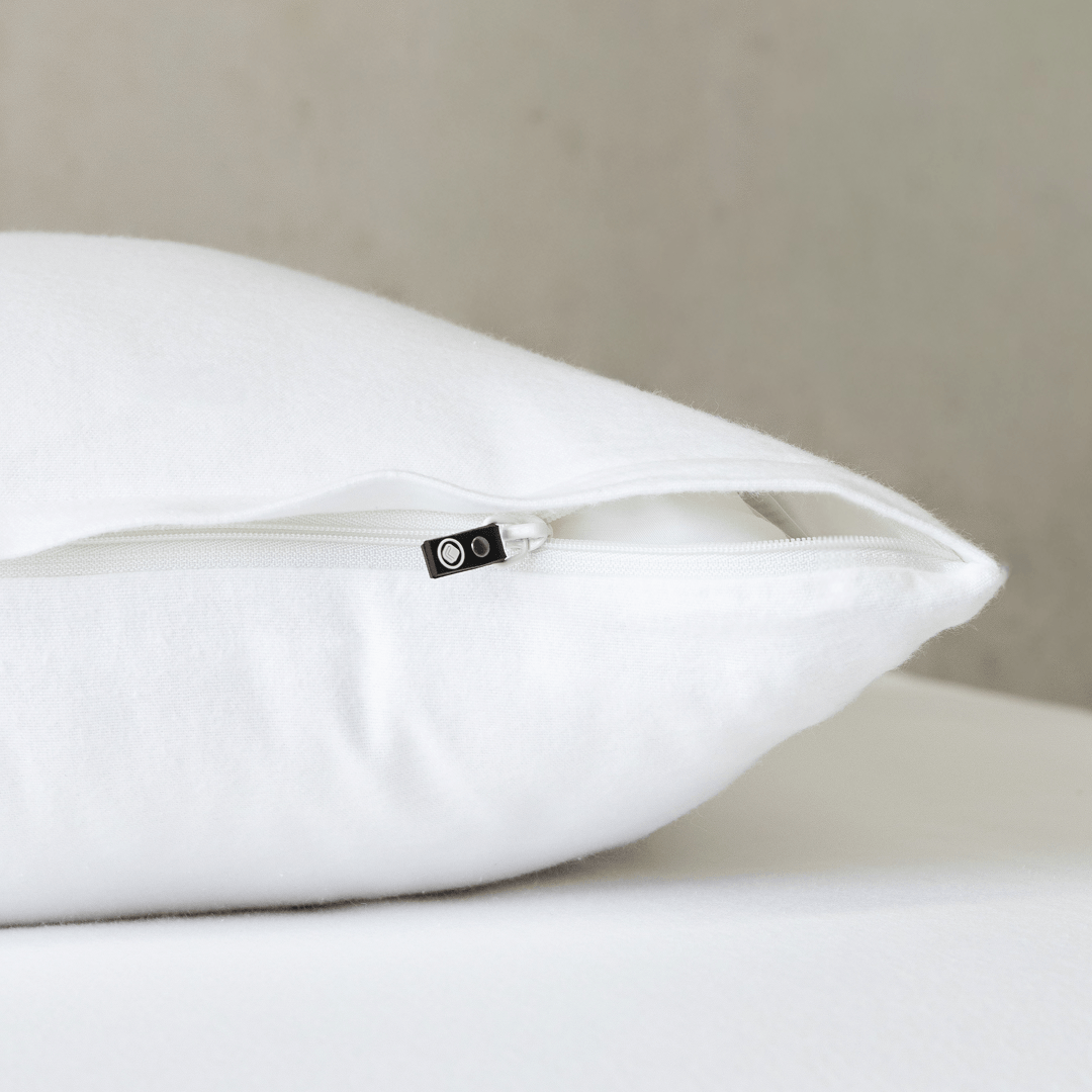 Close-up of a bright white pillowcase featuring a concealed zipper closure, highlighting the secure fastening detail and clean, crisp fabric finish.