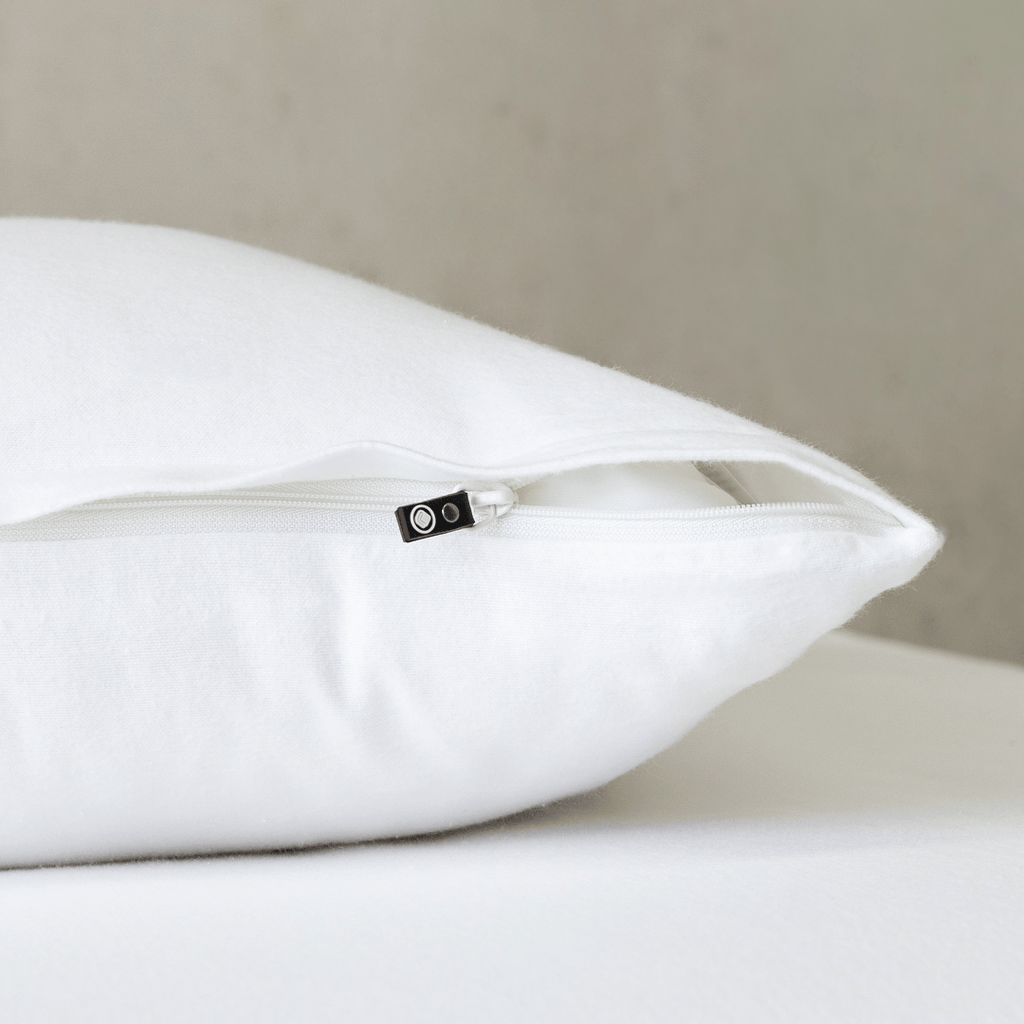 Close-up of a bright white pillowcase featuring a concealed zipper closure, highlighting the secure fastening detail and clean, crisp fabric finish.