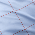 Extreme close-up showing fine red grid lines printed on smooth light blue fabric