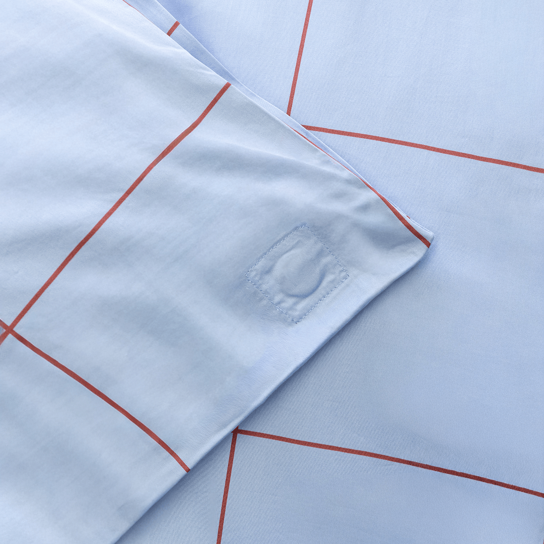 Close-up corner view of light blue grid fabric showing square-stitched corner reinforcement detail