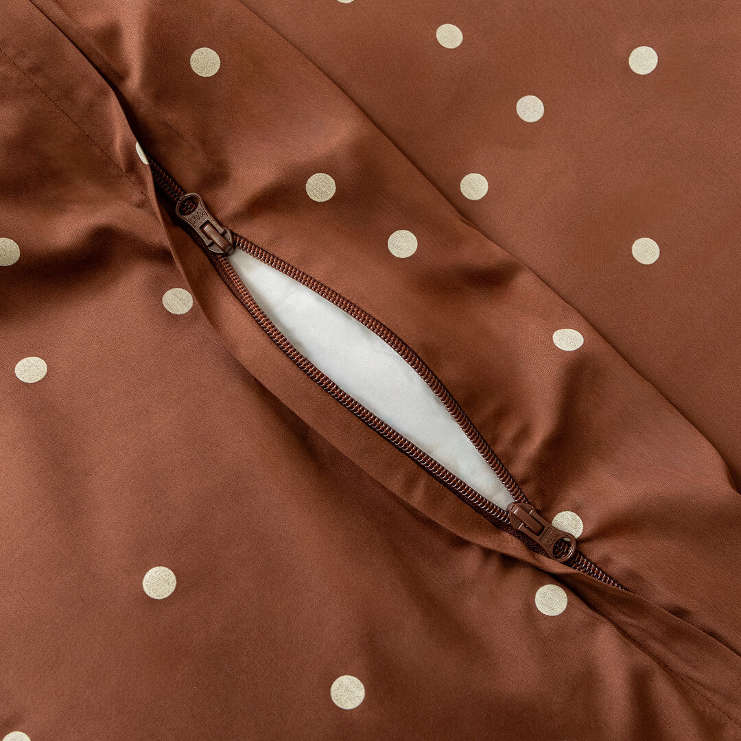 Brown fabric with white polka dots and a zipper.
