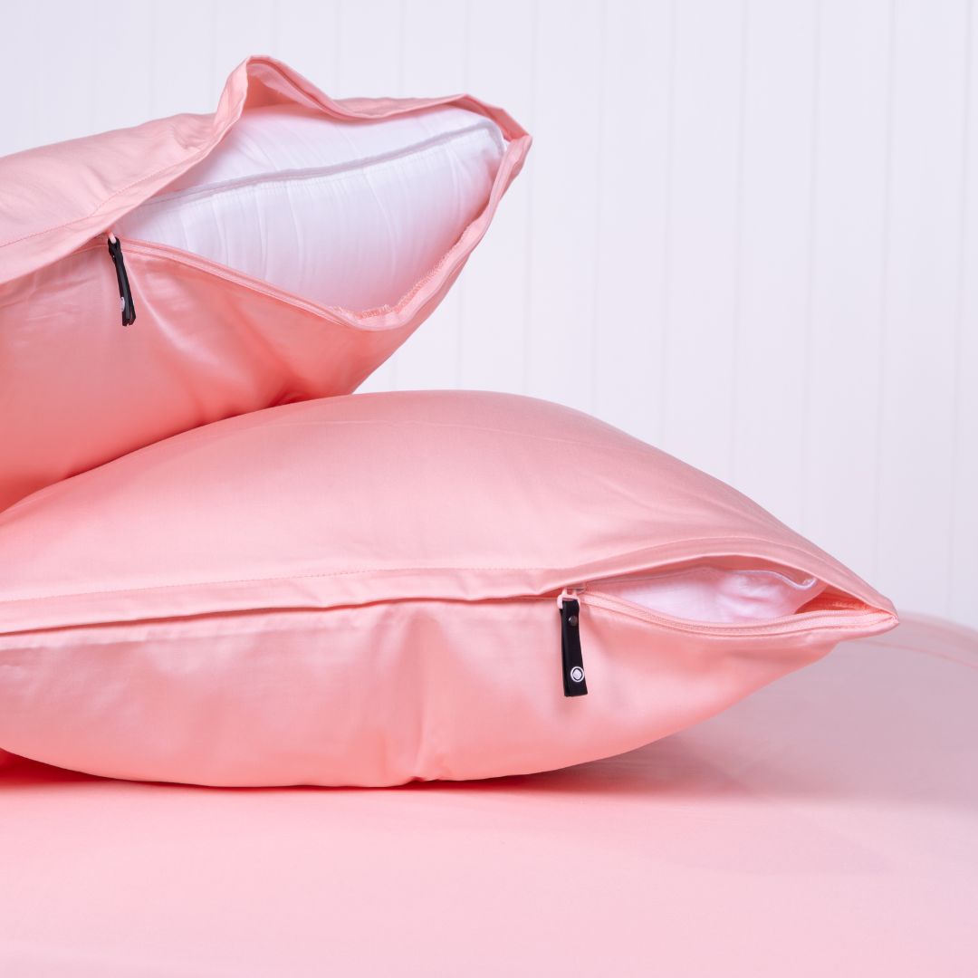 Two pink Streak Bay pillowcases with concealed zippers on a matching bed.