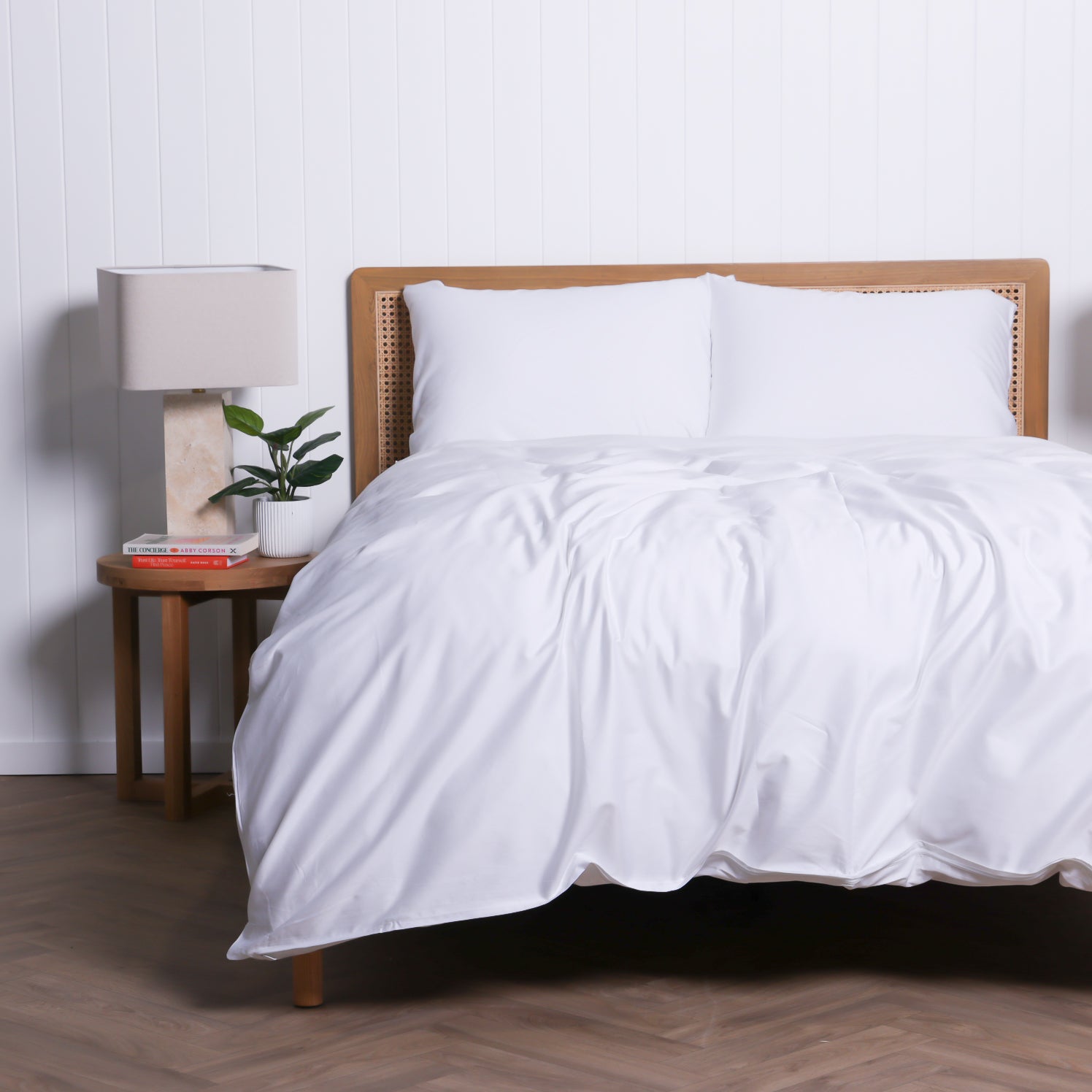 Bedroom featuring the Whitehaven quilt cover in white, framed by matching bedside tables and soft natural lighting.