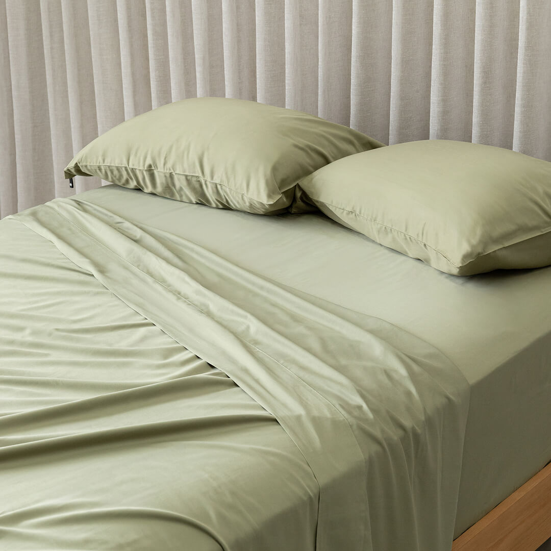 A neatly made bed with Daintree sheets
