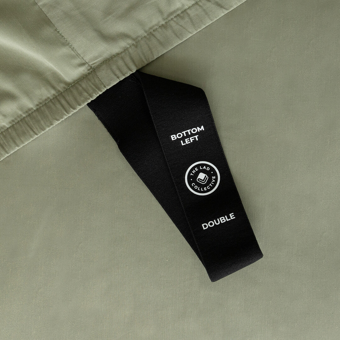 Bottom left label on a Daintree sage-green fitted-sheet corner loop